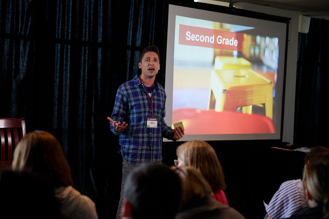 Ross presenting at Ed Rev Expo with 'Second Grade' on the slide behind him