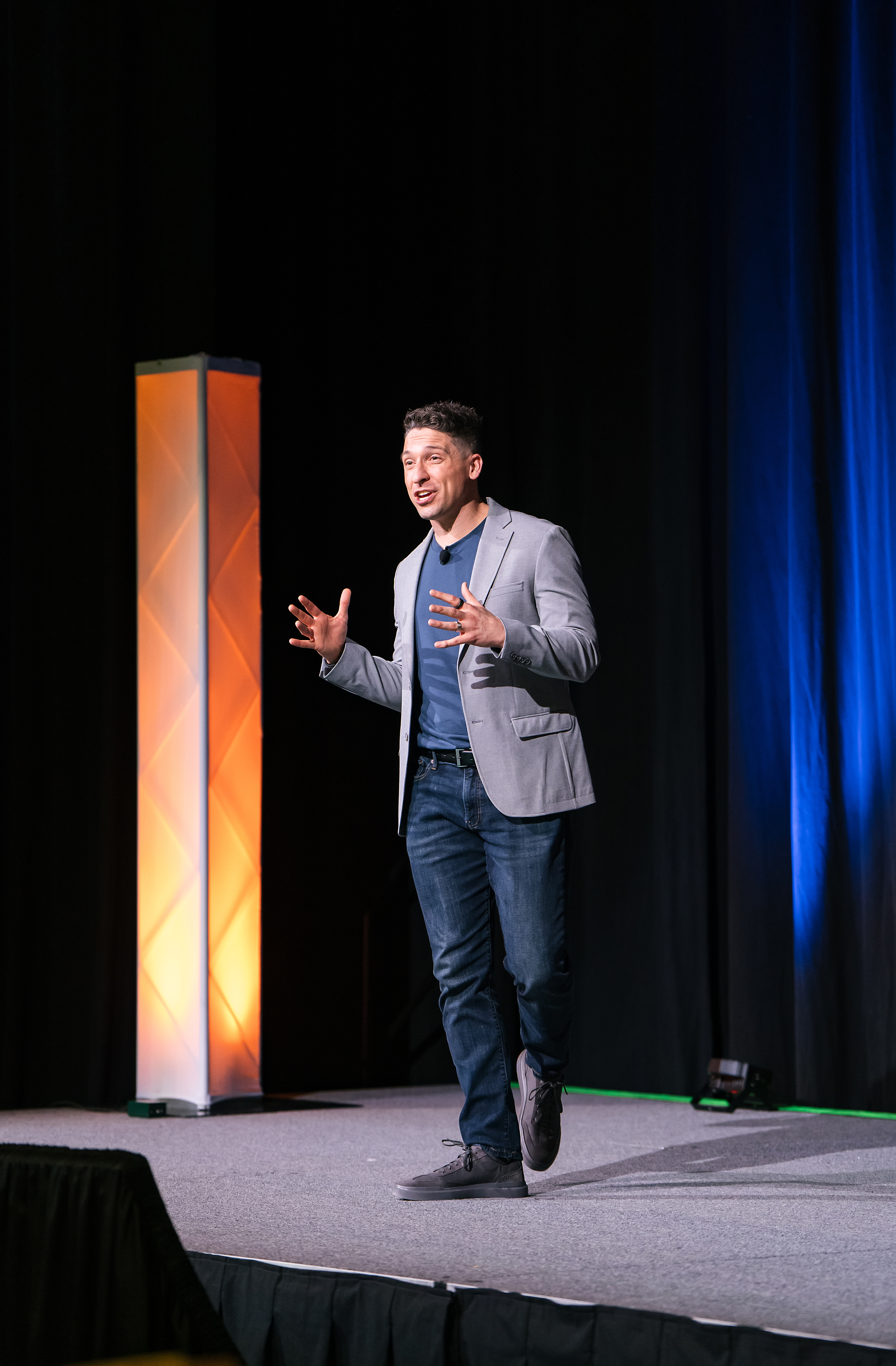 Ross on stage, full body, addressing the audience