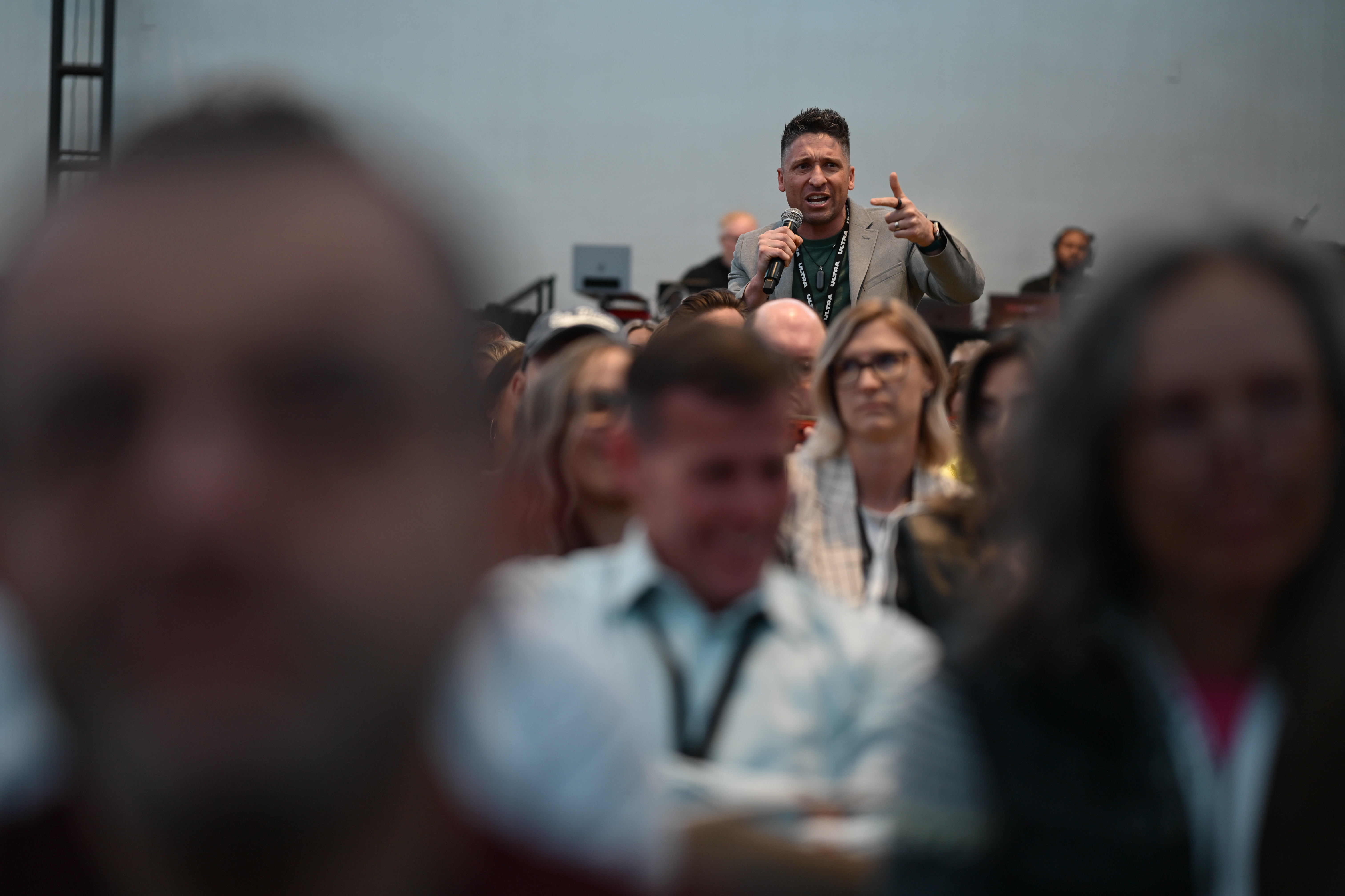 Ross speaking from among the audience at Ultra San Diego, microphone in hand